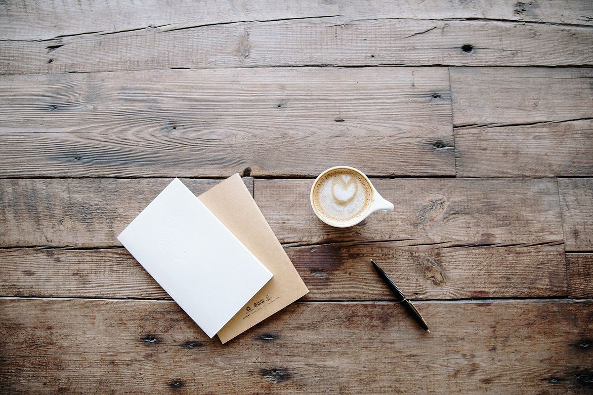 An open notebook and pen ready for writing out a monthly plan.